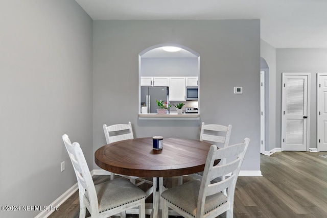 dining space with dark hardwood / wood-style flooring