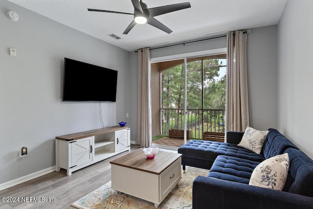 living room with light hardwood / wood-style flooring and ceiling fan