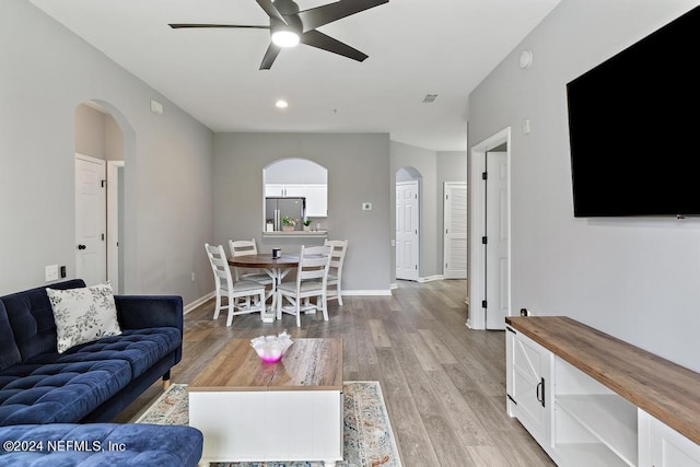 living room with ceiling fan and light wood-type flooring