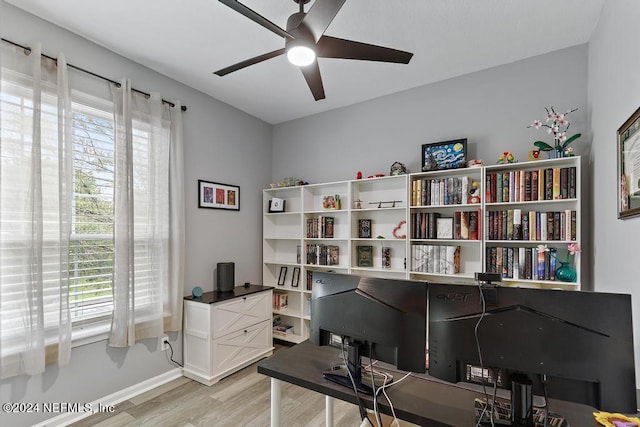 home office with light hardwood / wood-style flooring and ceiling fan