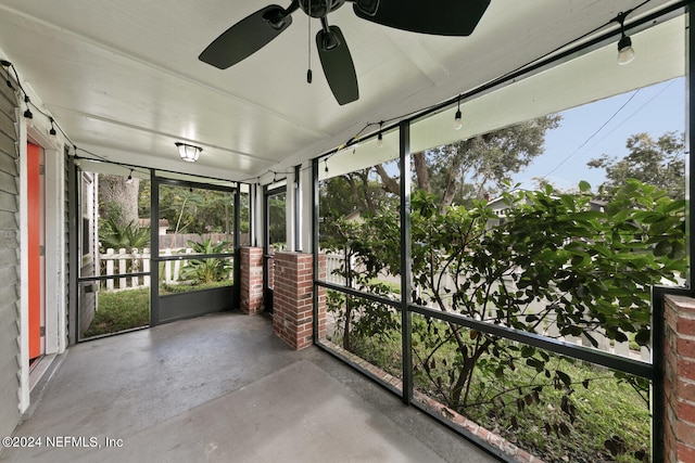 unfurnished sunroom with ceiling fan