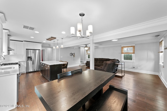 dining room featuring ceiling fan with notable chandelier, dark hardwood / wood-style floors, and ornamental molding