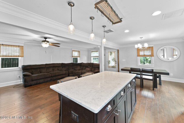 kitchen featuring dark wood-type flooring, a center island, and a healthy amount of sunlight