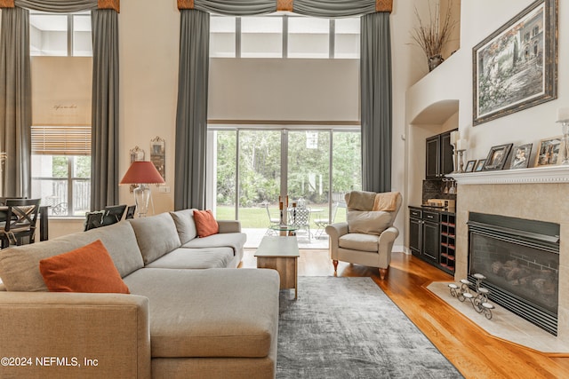 living room with plenty of natural light, a high ceiling, and hardwood / wood-style flooring