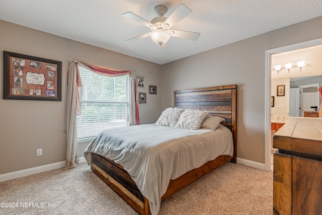 carpeted bedroom featuring ensuite bath, a textured ceiling, and ceiling fan