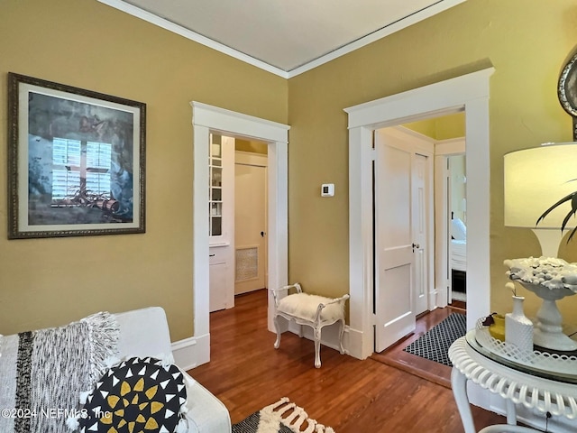 living area with ornamental molding and hardwood / wood-style flooring