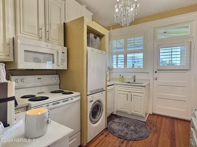 kitchen with plenty of natural light, stacked washer / drying machine, white appliances, and dark hardwood / wood-style flooring