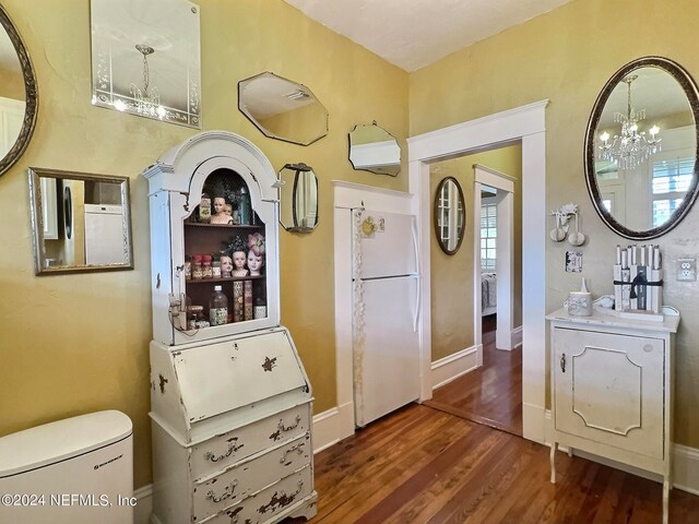 bathroom with wood-type flooring, toilet, and a notable chandelier