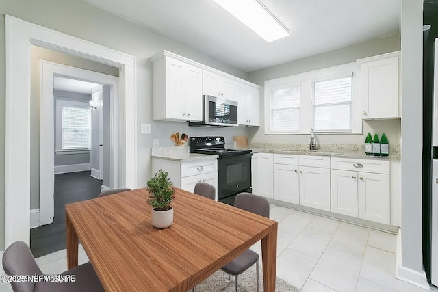 kitchen featuring sink, electric range, and white cabinets