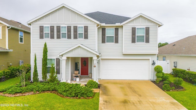 243 Bluejack Ln, Saint Augustine, FL 32095 - view of front of house with a front yard, an attached garage, board and batten siding, and driveway