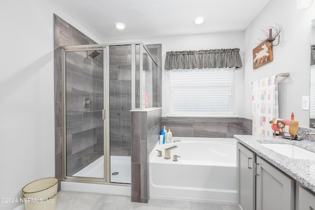 243 Bluejack Ln, Saint Augustine, FL 32095 - bathroom with tile patterned floors, a garden tub, a stall shower, a textured ceiling, and vanity