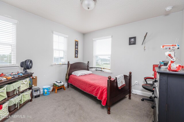 carpeted bedroom featuring a textured ceiling