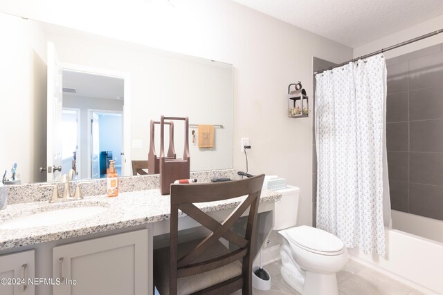 full bathroom featuring vanity, a textured ceiling, shower / bath combo, tile patterned flooring, and toilet