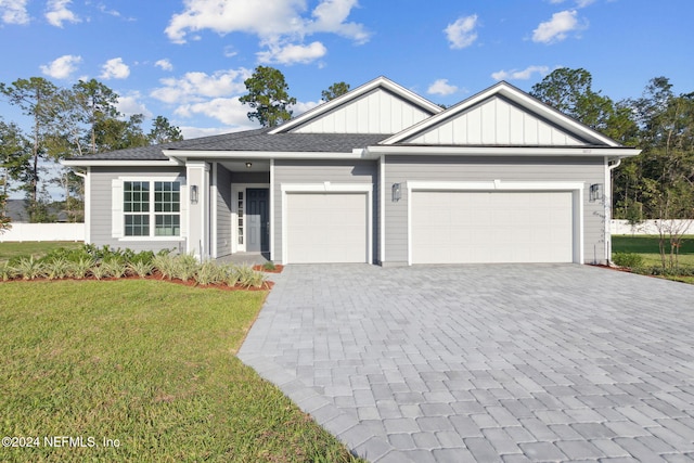 85212 Sandy Ridge Loop Unit 0023, Yulee, FL 32097 - view of front facade with an attached garage, a front lawn, decorative driveway, and board and batten siding