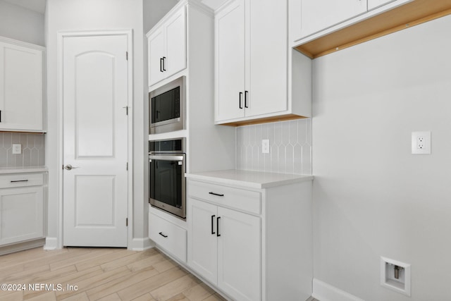 kitchen featuring light hardwood / wood-style flooring, white cabinets, stainless steel appliances, and tasteful backsplash