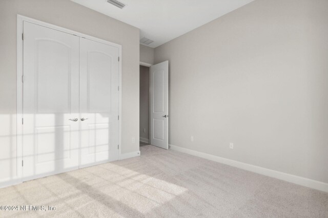 85212 Sandy Ridge Loop Unit 0023, Yulee, FL 32097 - unfurnished bedroom featuring carpet floors, baseboards, and a closet