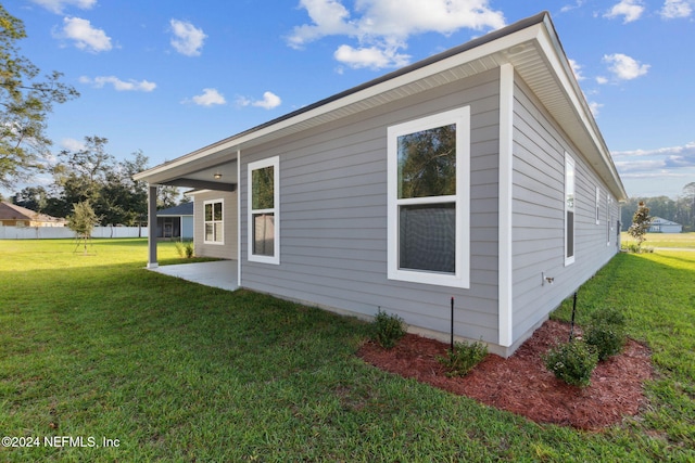 view of side of home with a yard and a patio area