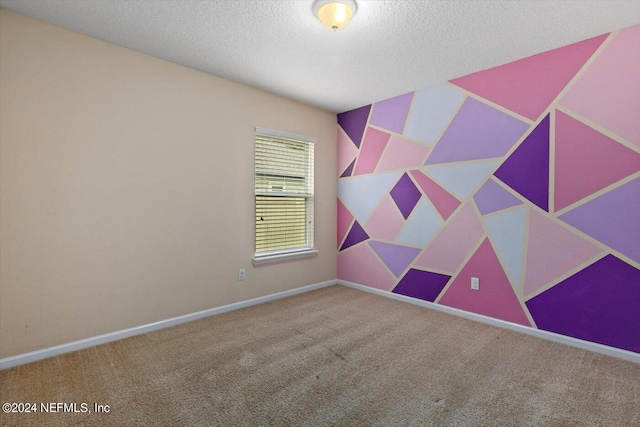 spare room featuring a textured ceiling and carpet floors