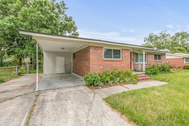 5246 Devron Dr, Jacksonville, FL 32209 - ranch-style home with driveway, brick siding, and an attached carport