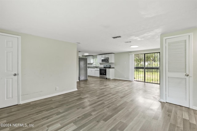 5246 Devron Dr, Jacksonville, FL 32209 - unfurnished living room featuring wood finished floors and baseboards