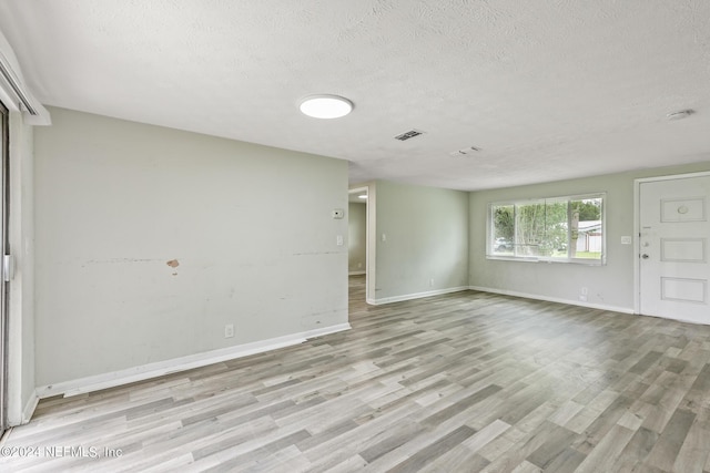 5246 Devron Dr, Jacksonville, FL 32209 - spare room featuring a textured ceiling, light wood-style floors, and baseboards