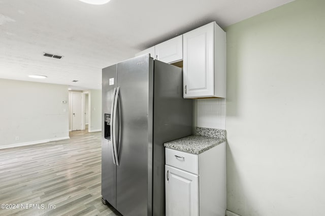 5246 Devron Dr, Jacksonville, FL 32209 - kitchen featuring stainless steel fridge with ice dispenser, white cabinets, light wood finished floors, decorative backsplash, and light stone counters
