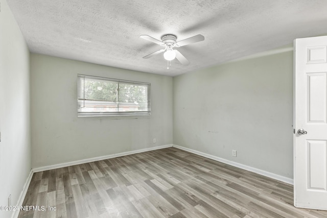 5246 Devron Dr, Jacksonville, FL 32209 - spare room featuring wood finished floors, a ceiling fan, a textured ceiling, and baseboards