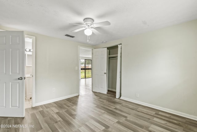5246 Devron Dr, Jacksonville, FL 32209 - unfurnished bedroom with wood finished floors, baseboards, a closet, and a textured ceiling