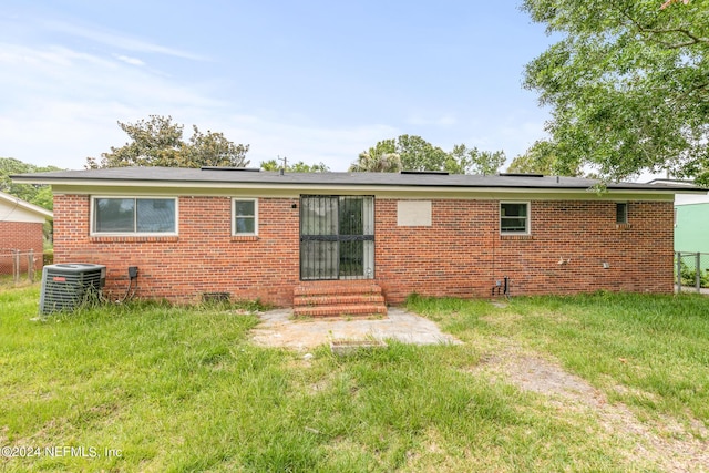 5246 Devron Dr, Jacksonville, FL 32209 - back of property with entry steps, central AC, brick siding, and roof mounted solar panels