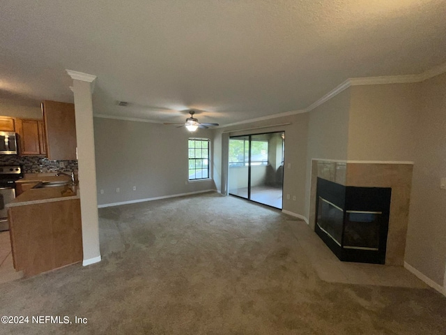 unfurnished living room with light carpet, sink, ceiling fan, a multi sided fireplace, and a textured ceiling