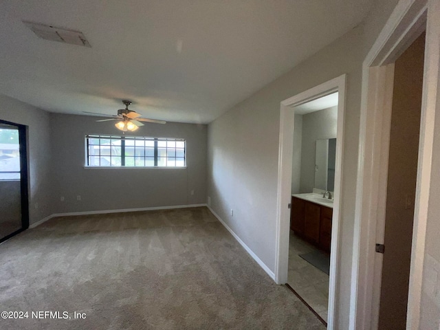 empty room with ceiling fan, sink, and light carpet