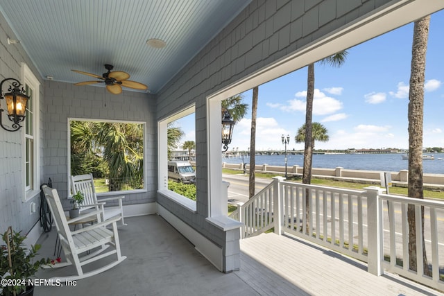 sunroom / solarium featuring a water view and ceiling fan