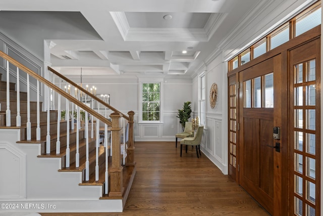 foyer entrance featuring a chandelier, beamed ceiling, dark hardwood / wood-style floors, coffered ceiling, and ornamental molding