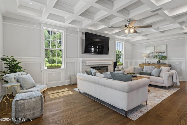 living room featuring a brick fireplace, ceiling fan, beamed ceiling, and hardwood / wood-style flooring