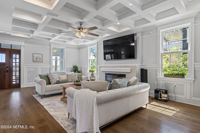 living room featuring ceiling fan, beam ceiling, coffered ceiling, hardwood / wood-style flooring, and a fireplace