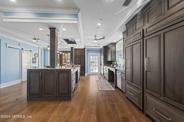 kitchen with dark hardwood / wood-style flooring, decorative columns, ceiling fan, and a barn door