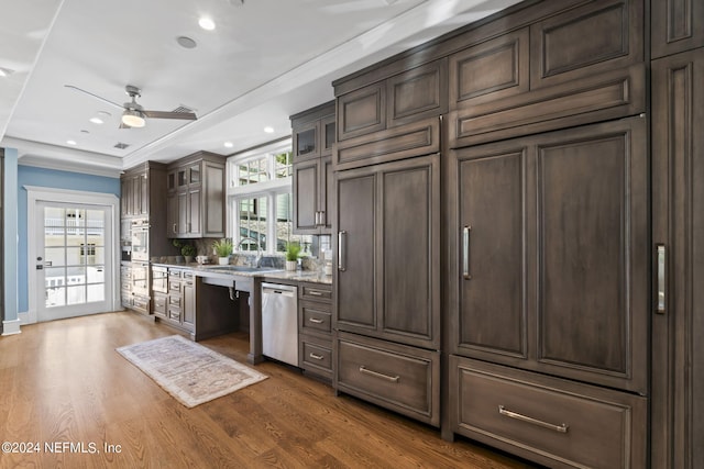 kitchen featuring dishwasher, ceiling fan, hardwood / wood-style flooring, dark brown cabinetry, and sink