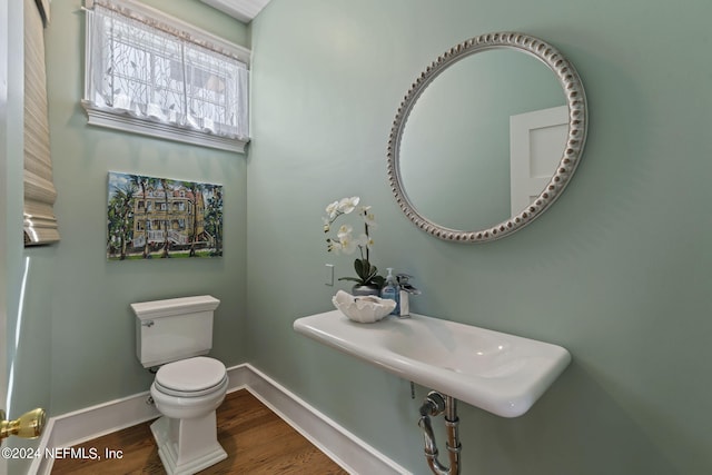 bathroom featuring wood-type flooring and toilet