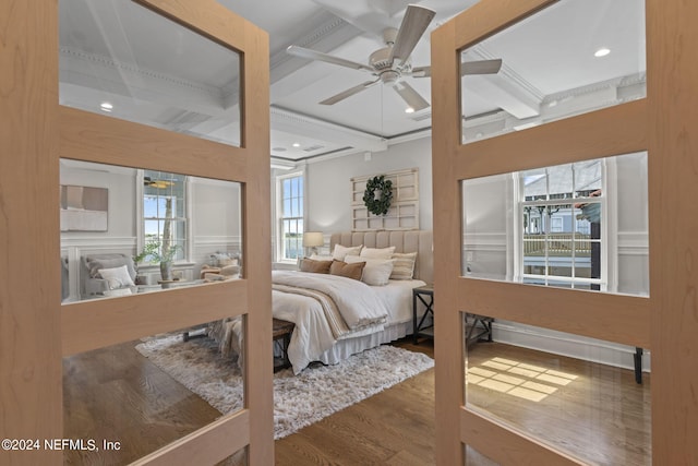 bedroom featuring wood-type flooring, coffered ceiling, beam ceiling, and ceiling fan