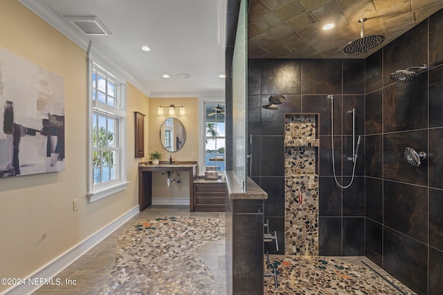 bathroom with vanity, crown molding, and tiled shower