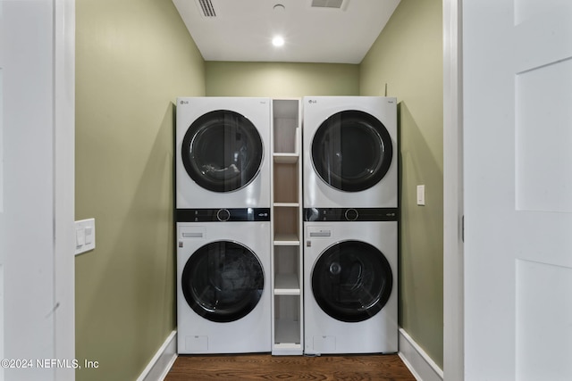 laundry room with stacked washer / dryer and dark wood-type flooring