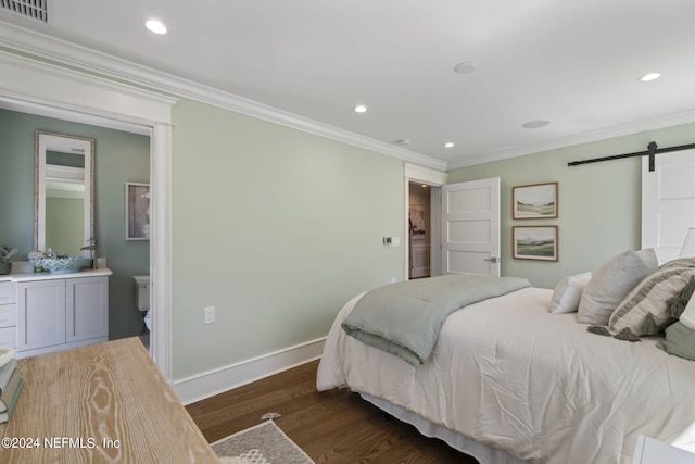 bedroom featuring dark hardwood / wood-style flooring, ensuite bath, ornamental molding, and a barn door