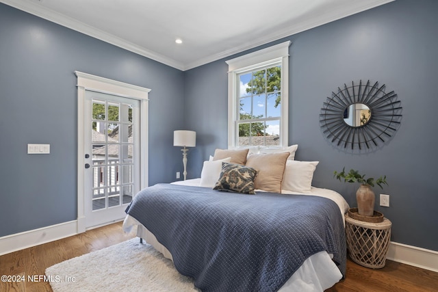 bedroom featuring hardwood / wood-style flooring, ornamental molding, and access to exterior