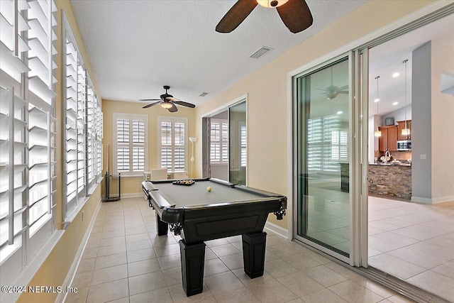 recreation room with pool table, light tile patterned floors, a textured ceiling, and ceiling fan