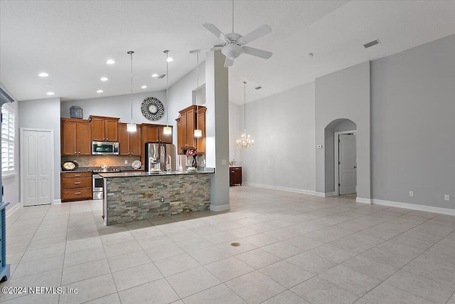 kitchen with ceiling fan with notable chandelier, appliances with stainless steel finishes, and high vaulted ceiling