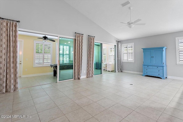 tiled spare room featuring plenty of natural light, ceiling fan, and high vaulted ceiling