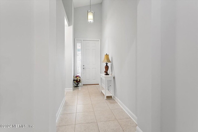 corridor with high vaulted ceiling and light tile patterned flooring