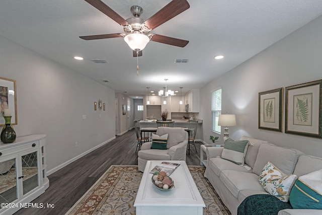 living room featuring dark hardwood / wood-style flooring and ceiling fan with notable chandelier