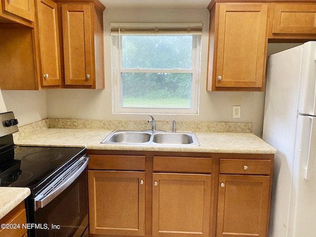 kitchen featuring electric stove, white refrigerator, and sink