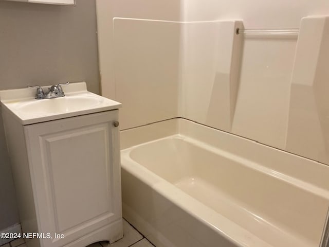 bathroom with vanity, tile patterned flooring, and a washtub